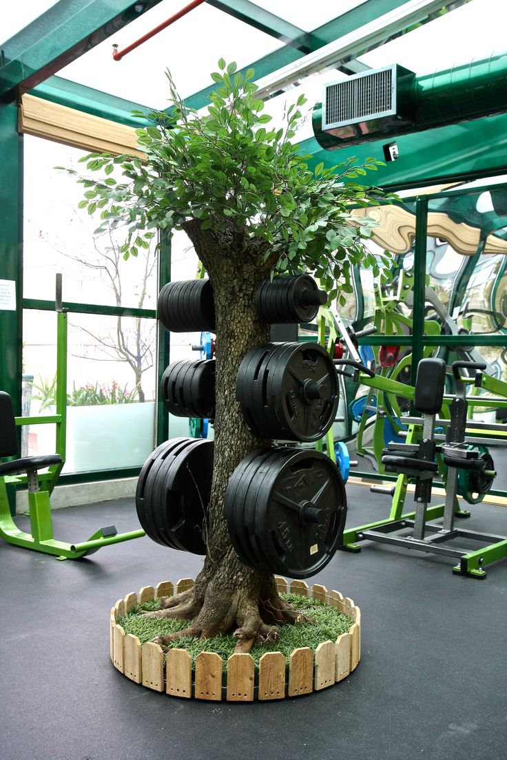 a tree made out of old tires is in the middle of an indoor gym area