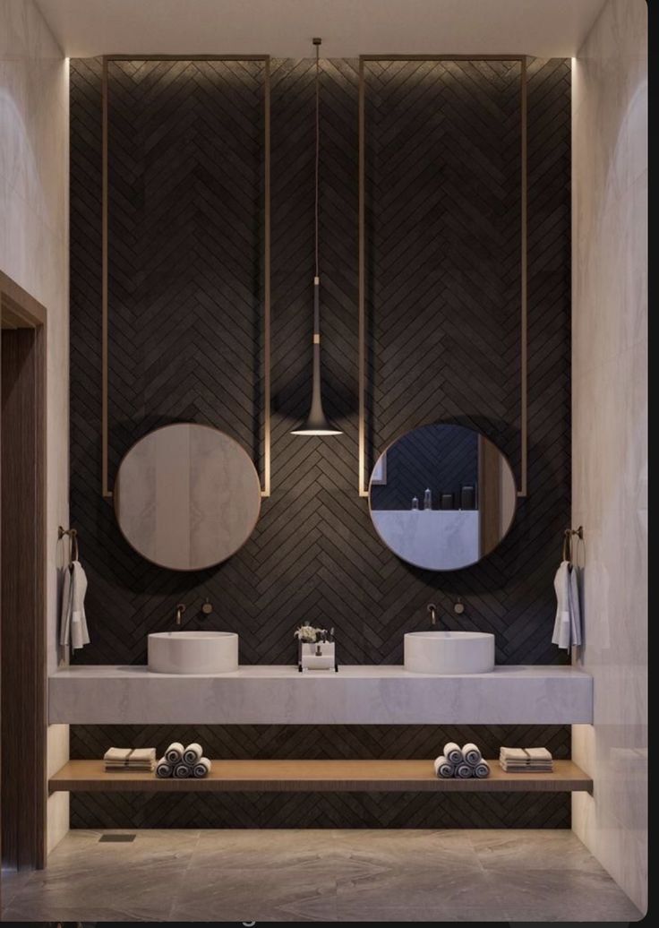 a bathroom with two sinks and mirrors in the wall above them is lit by lights