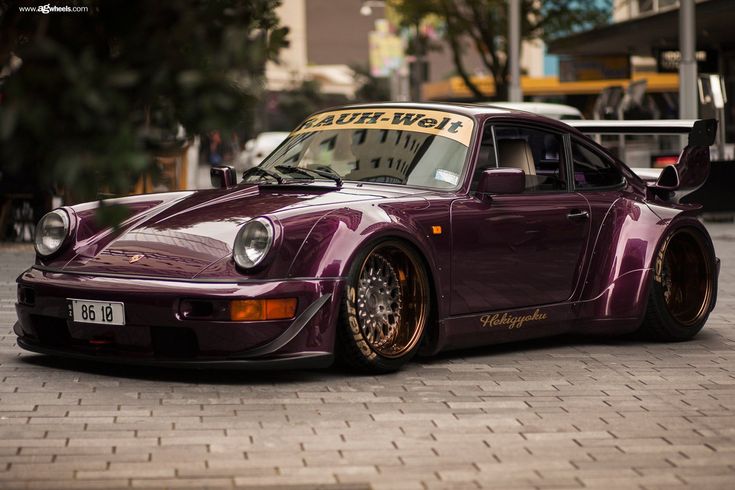 a purple sports car parked in front of a building