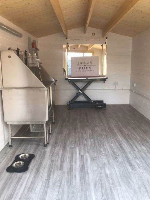 the inside of a trailer with wood floors and white walls