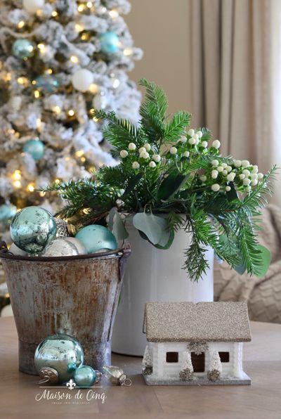 a potted plant sitting on top of a wooden table next to a christmas tree