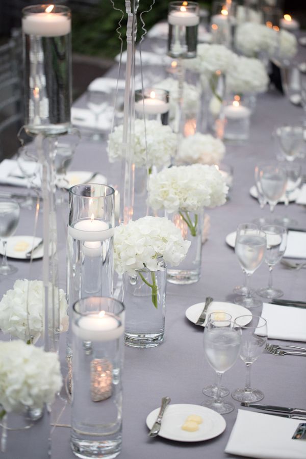 the table is set with white flowers and candles