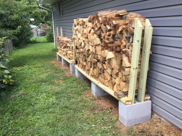 several stacks of wood sitting on the side of a house