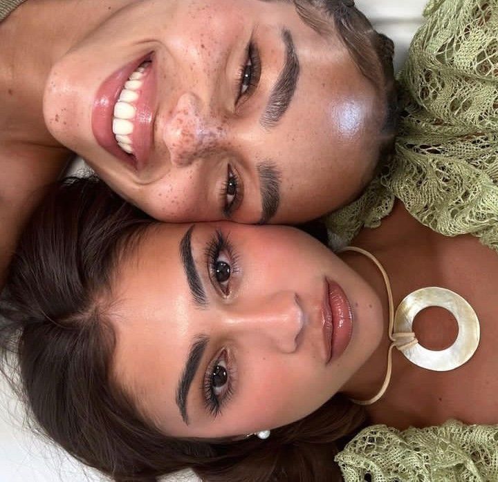 two beautiful young women laying next to each other