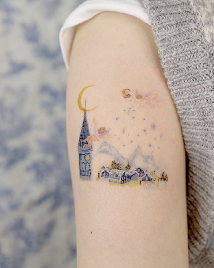 a woman with a tattoo on her arm that has a castle and moon in it