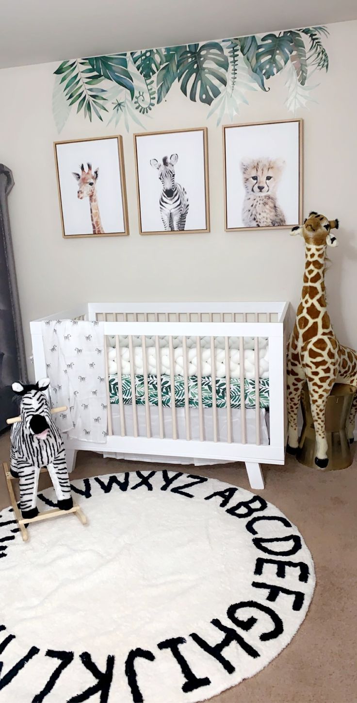 a baby's room with zebras and giraffes on the rug