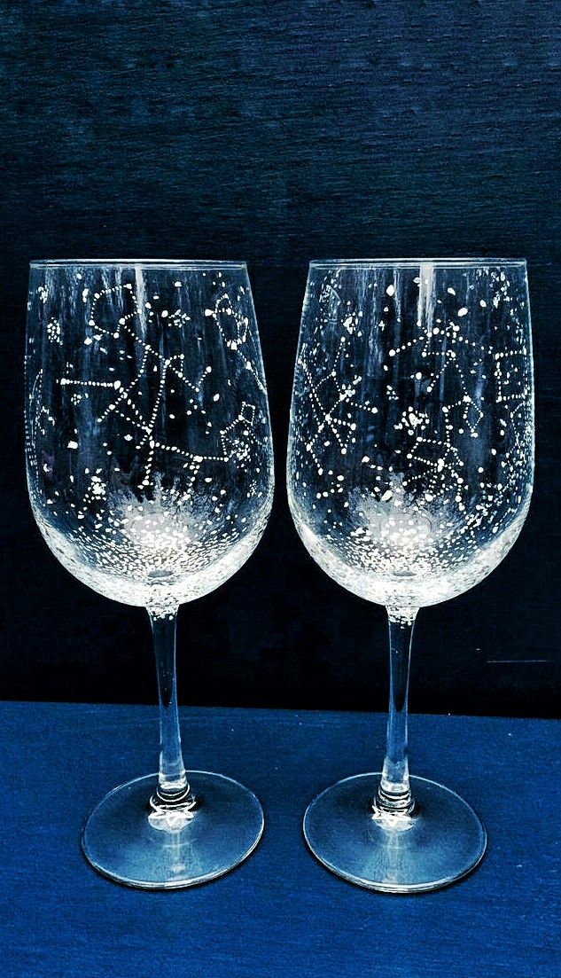 two wine glasses with stars on them sitting side by side in front of a blue background