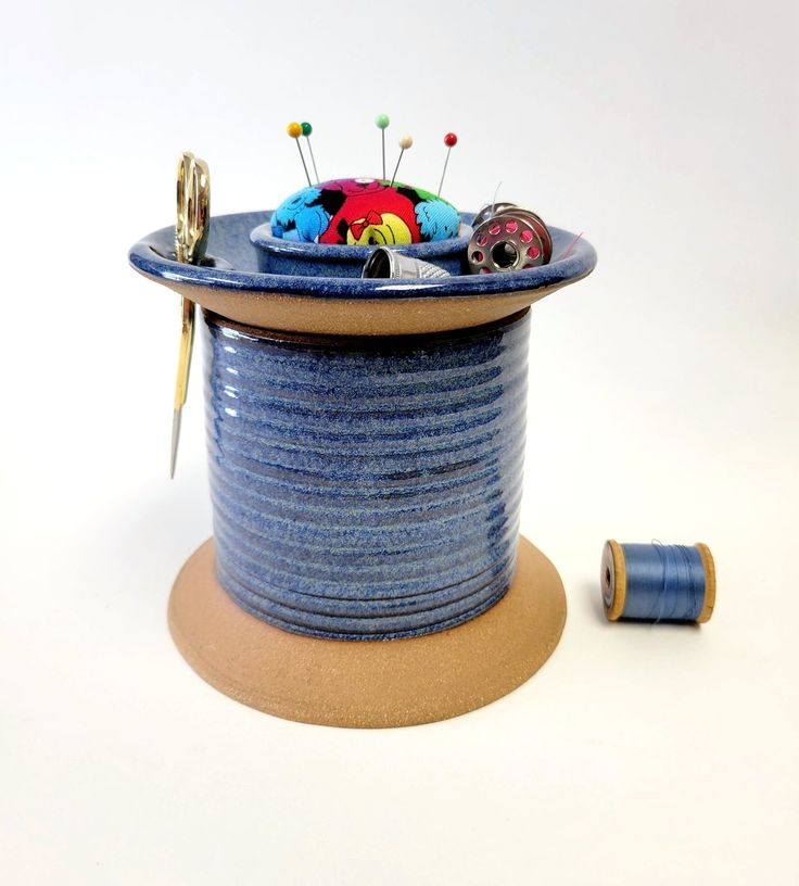 a spool of thread sitting on top of a blue container