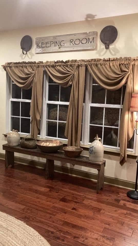 a living room filled with furniture and windows next to a wooden floor covered in curtains