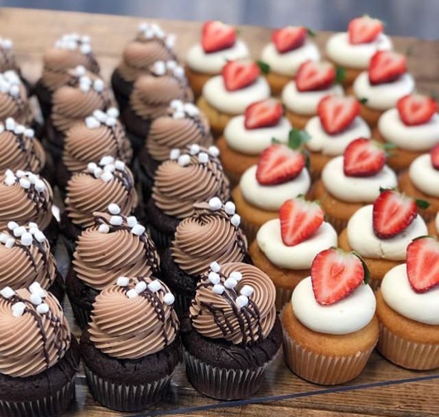 cupcakes and strawberries are arranged on a table