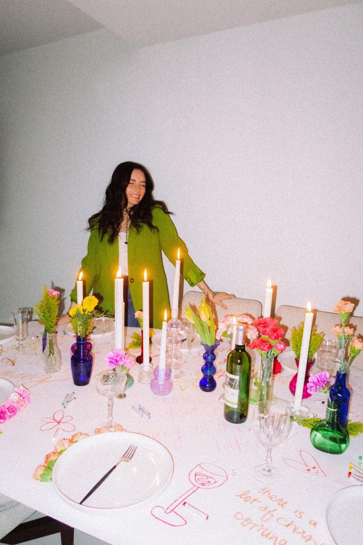 a woman sitting at a table with candles on it