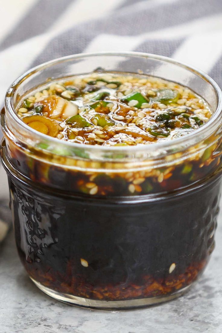 a glass jar filled with food sitting on top of a white and black table cloth