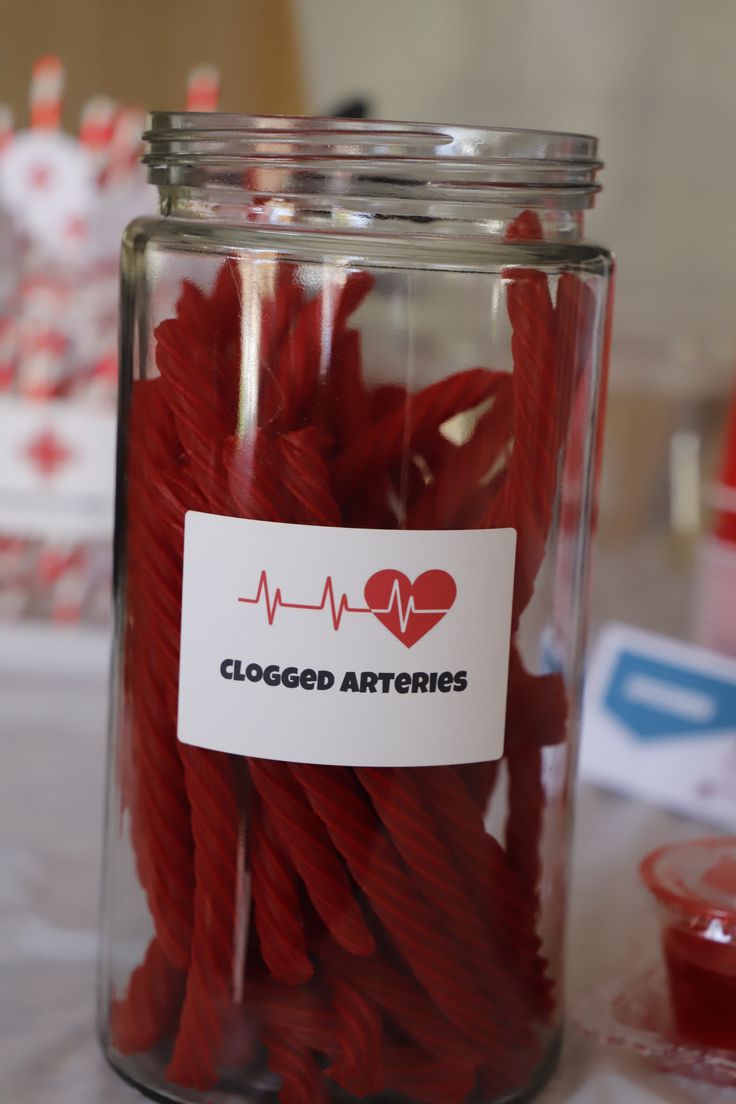 a glass jar filled with red string and a sticker that says, closed attrites