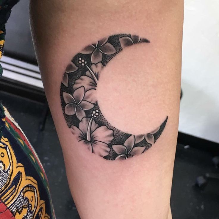 a black and white photo of a flowered crescent tattoo