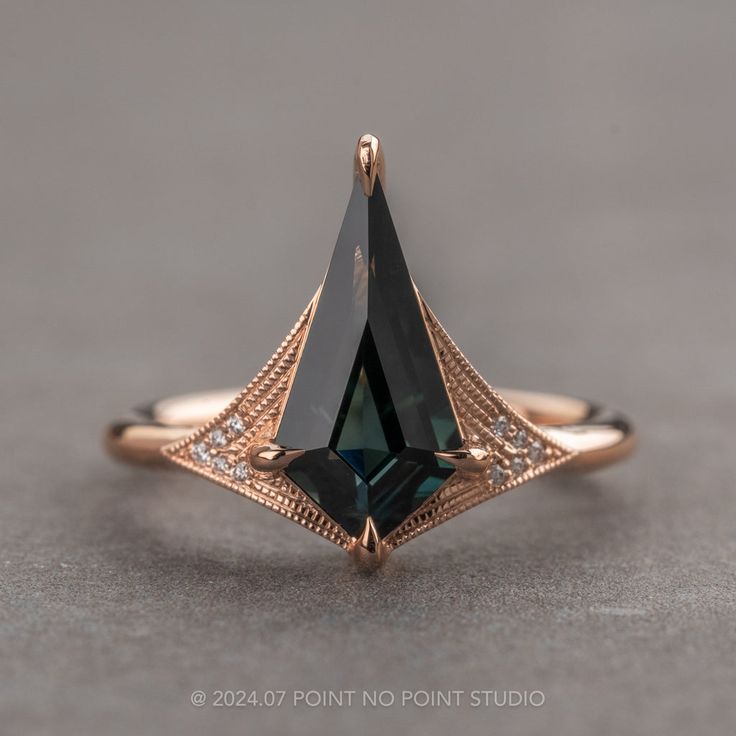 a close up of a ring with a black diamond in the center and diamonds around it