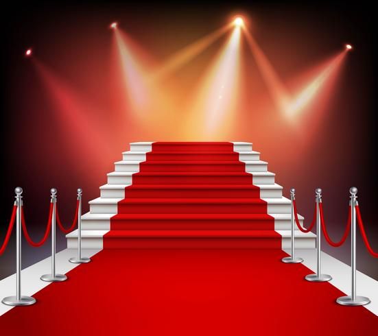 a red carpeted staircase with white railings leading up to bright spotlights on the stage