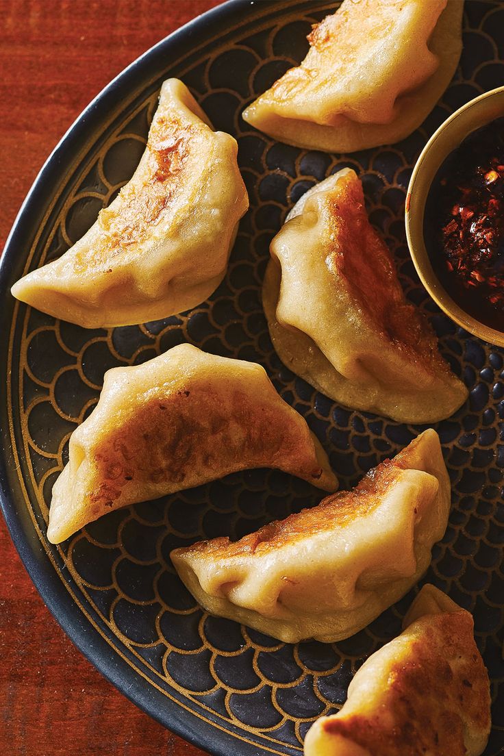 some dumplings are on a plate with dipping sauce