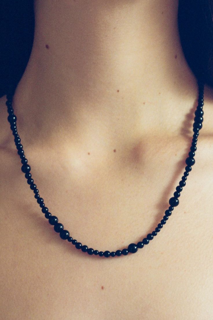 Sophie Buhai is a LA-based jewelry designer whose namesake line has renewed the modernist tradition of sterling silver with an emphasis on sculptural silhouettes. All of her pieces are hand made by artisans in Los Angeles using recycled metals. The Constellation Necklace showcases a range of onyx beads on a silk thread and is secured with a sterling silver fastener. 20”15.1 gBead size varies from 3-6mm Made in Los Angeles Elegant Black Hand Forged Necklace, Black Sterling Silver Timeless Necklace, Timeless Black Sterling Silver Necklace, Minimalist Onyx Bead Jewelry, Minimalist Onyx Round Bead Jewelry, Minimalist Onyx Jewelry For Formal Occasions, Modern Black Jewelry With Sterling Silver Clasp, Minimalist Onyx Jewelry With Black Beads, Gift Onyx Single Strand Jewelry