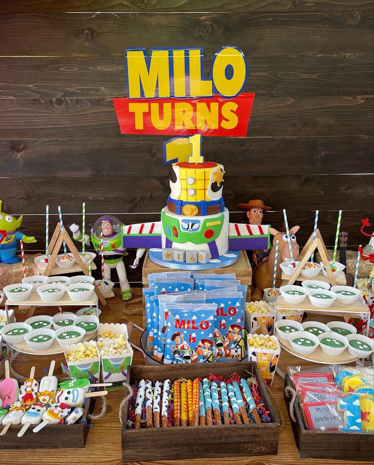 a table filled with lots of food on top of wooden trays next to a sign that says millo turns