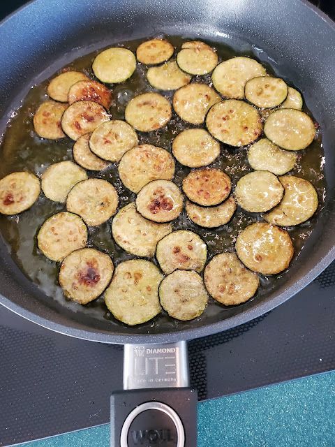 some food is being cooked in a frying pan on the stove top with water