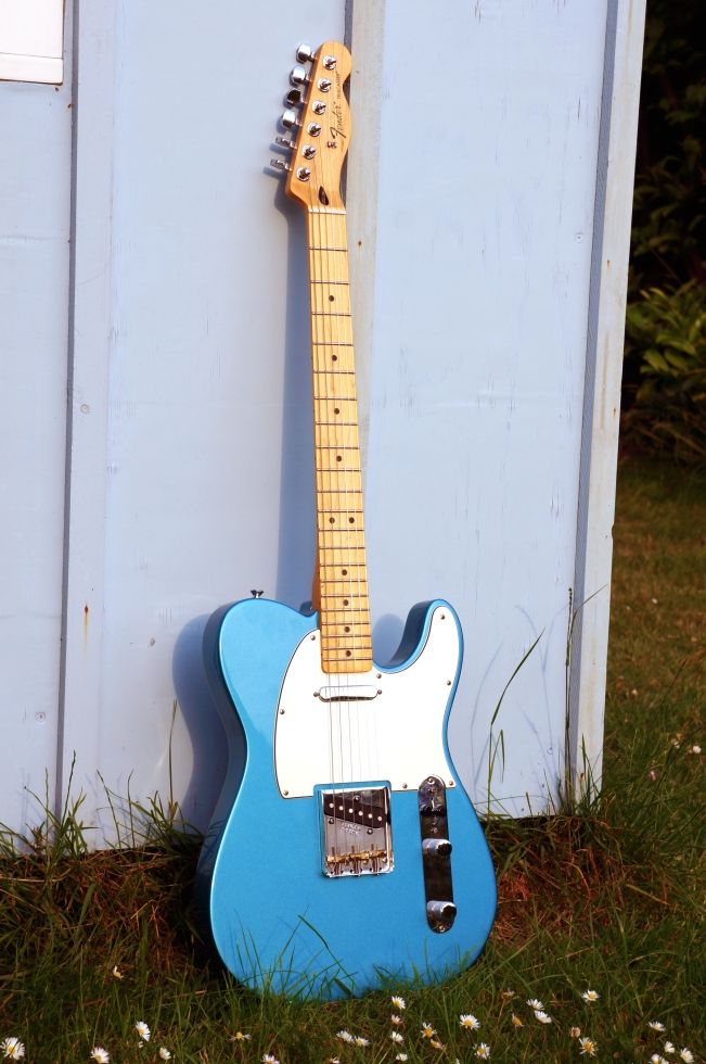 a blue and white guitar leaning against a wall