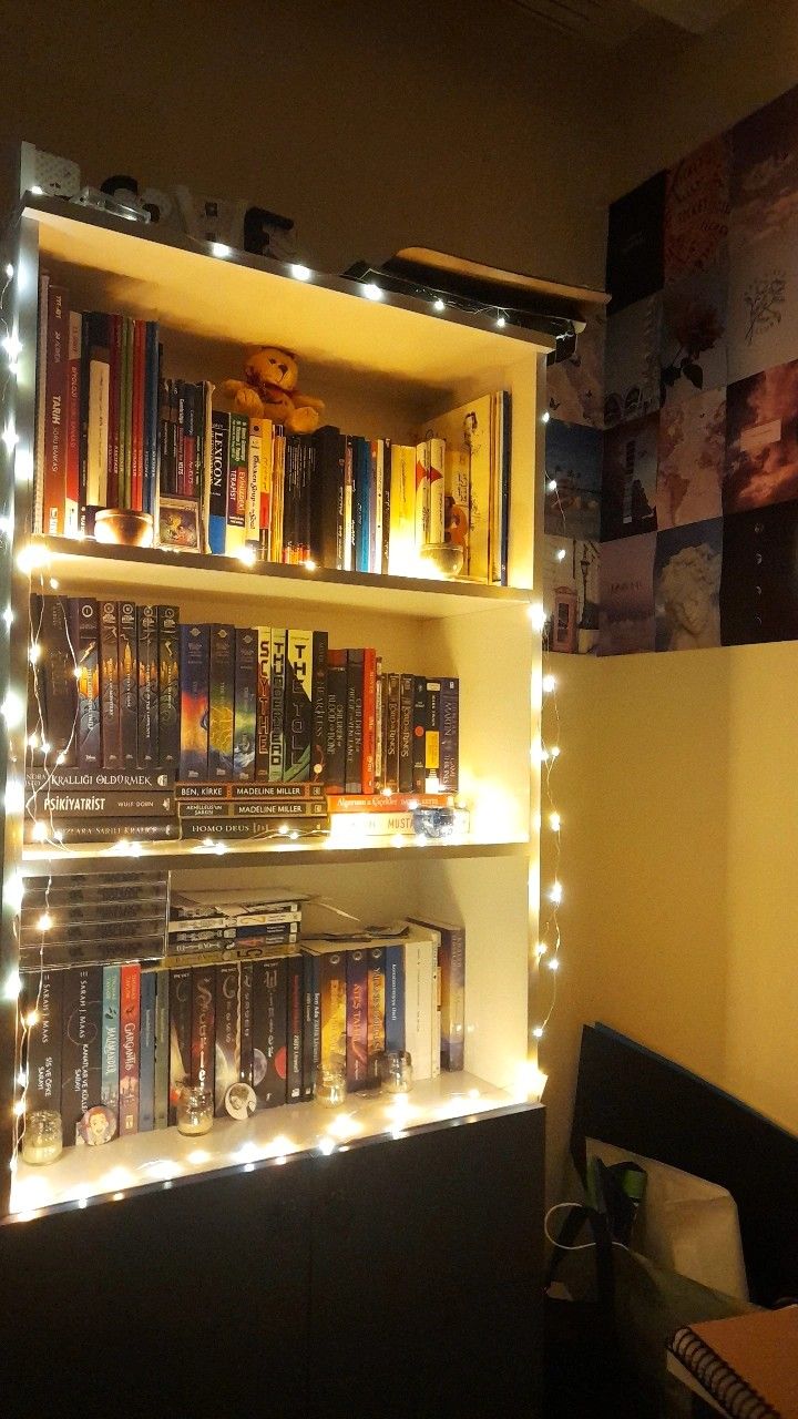 a bookshelf filled with lots of books and lights