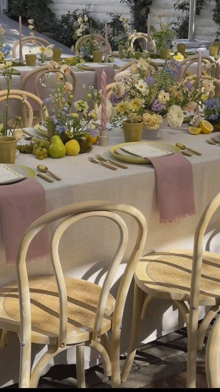 the table is set with flowers, fruit and candles for an elegant dinner or party