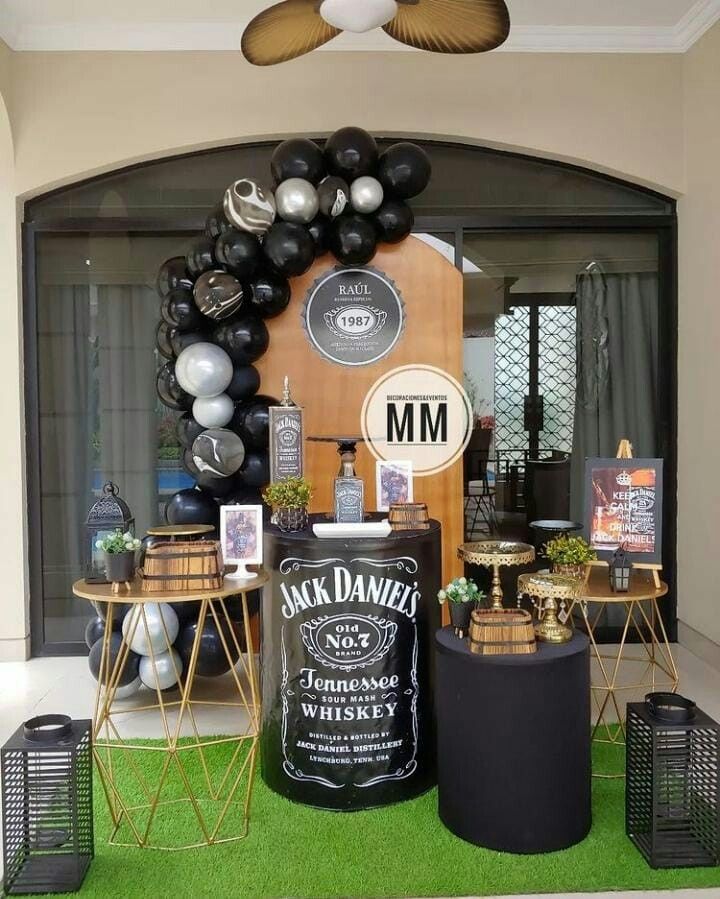 an outdoor bar with balloons and decorations on the outside wall, along with black and white decor