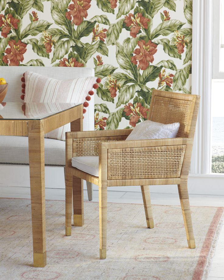 two chairs and a table in front of a floral wallpaper with flowers on it