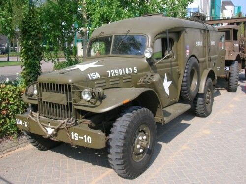 an army truck is parked on the side of the road