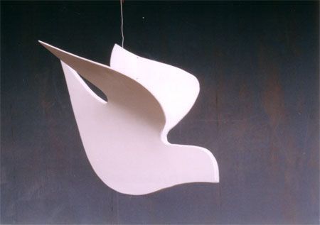 a white sculpture hanging from the side of a wall