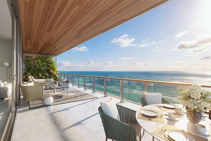 a balcony overlooking the ocean with wicker chairs and table set for four on it