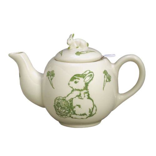 a white teapot with green designs on it