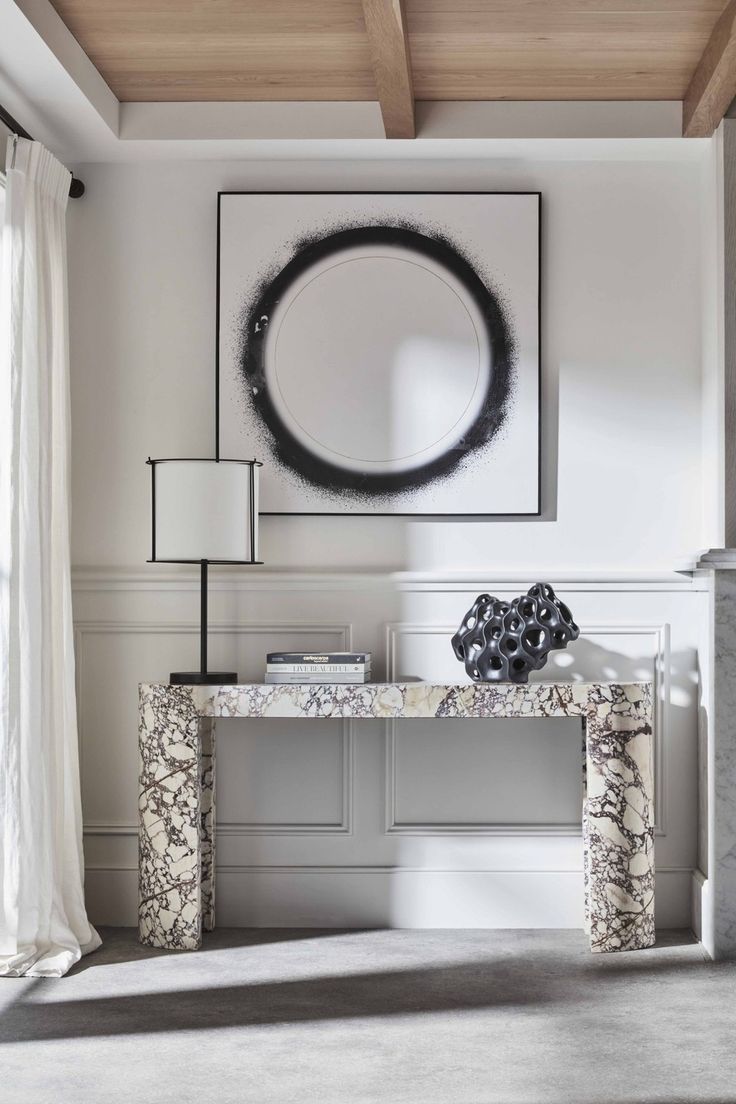 a living room with a large painting on the wall and a console table in front of it