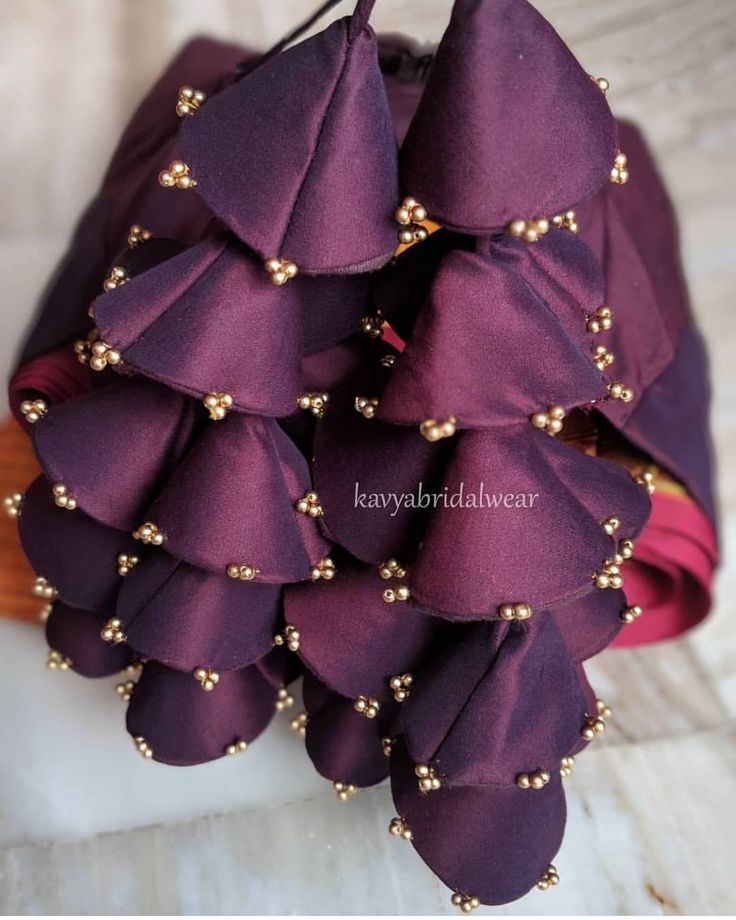 a bunch of purple flowers with gold beads on them