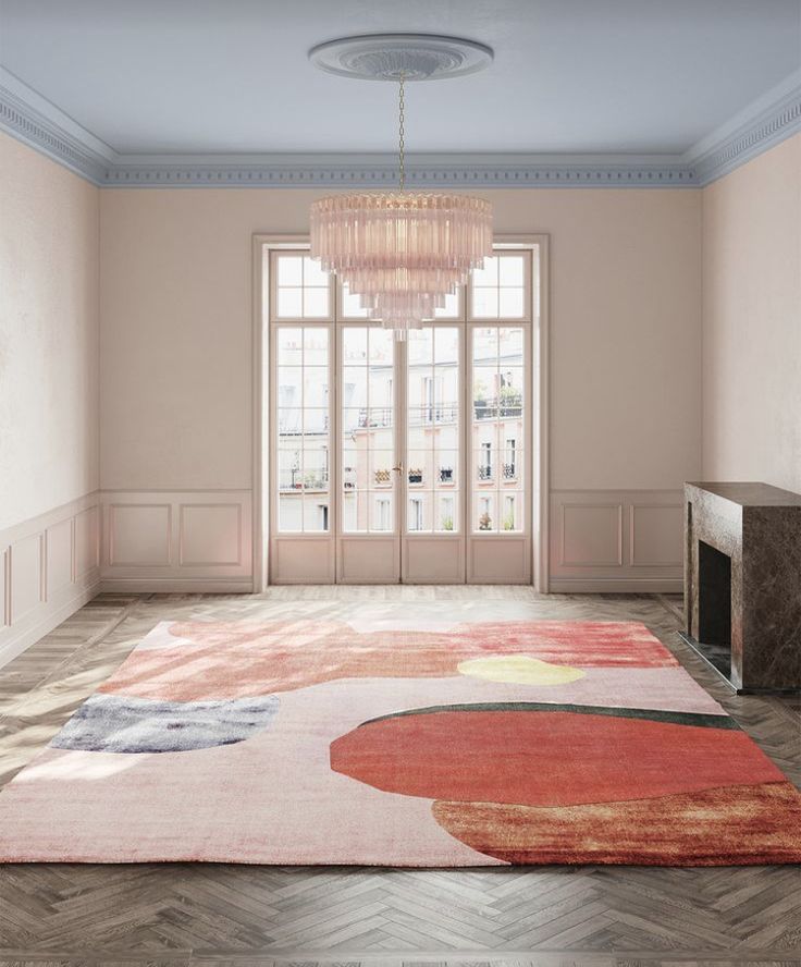 an empty room with a chandelier hanging from the ceiling and rug on the floor