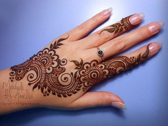 a woman's hand with henna tattoos on it