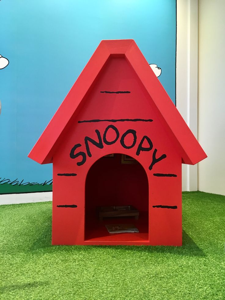 a red dog house with the word snoopy written on it