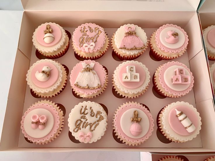 cupcakes decorated with pink and white icing in a box