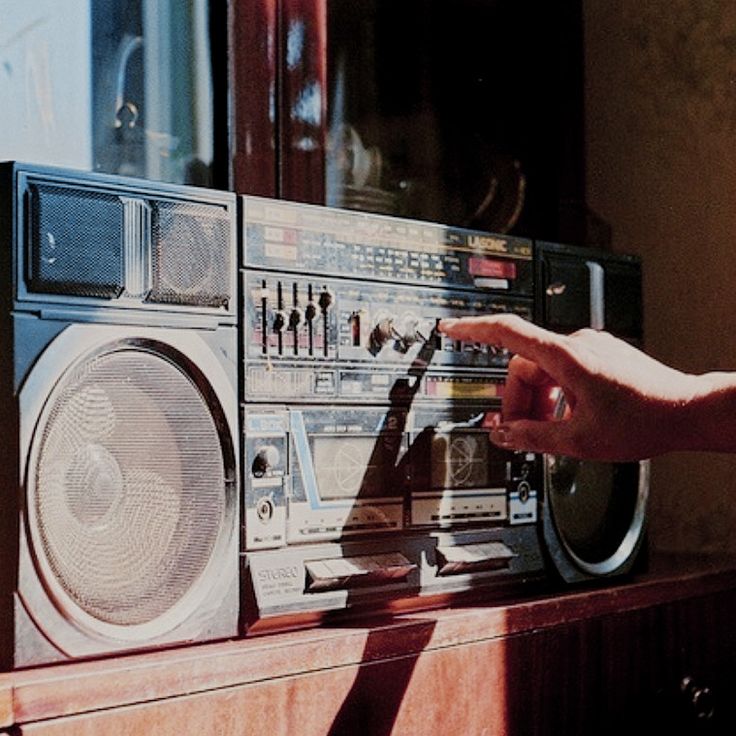 a person touching the radio on top of a table