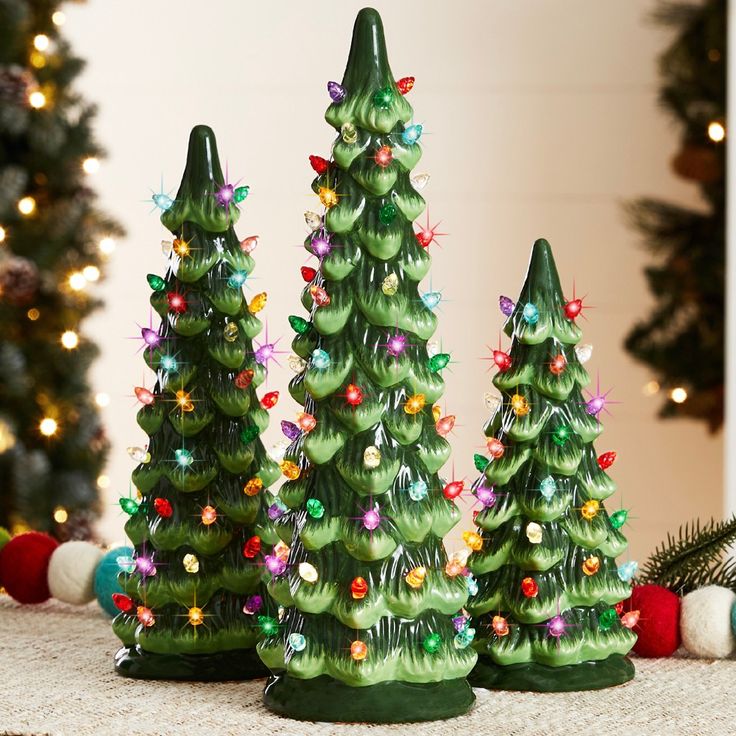 three small christmas trees with lights on them