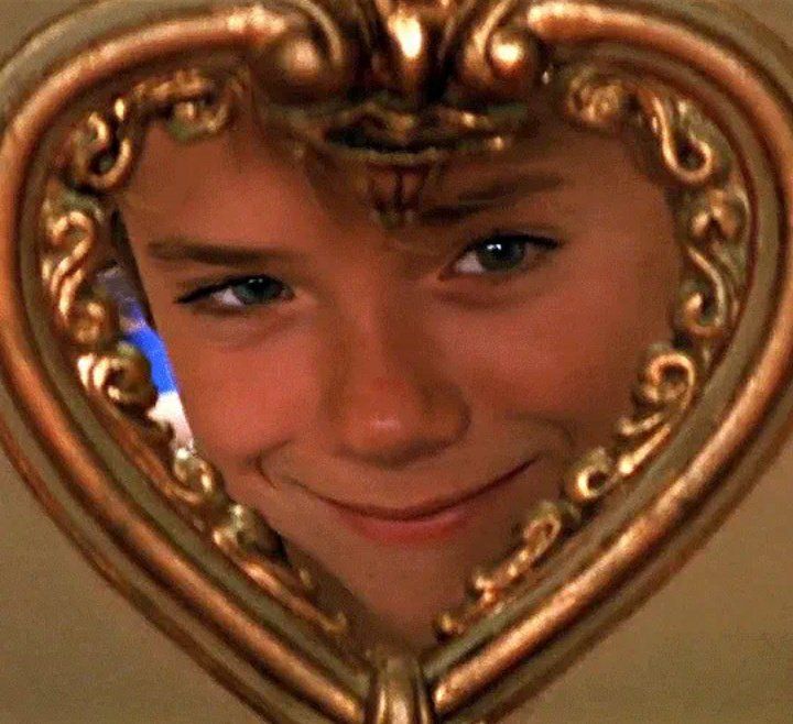 a close up of a person's face in a heart shaped mirror