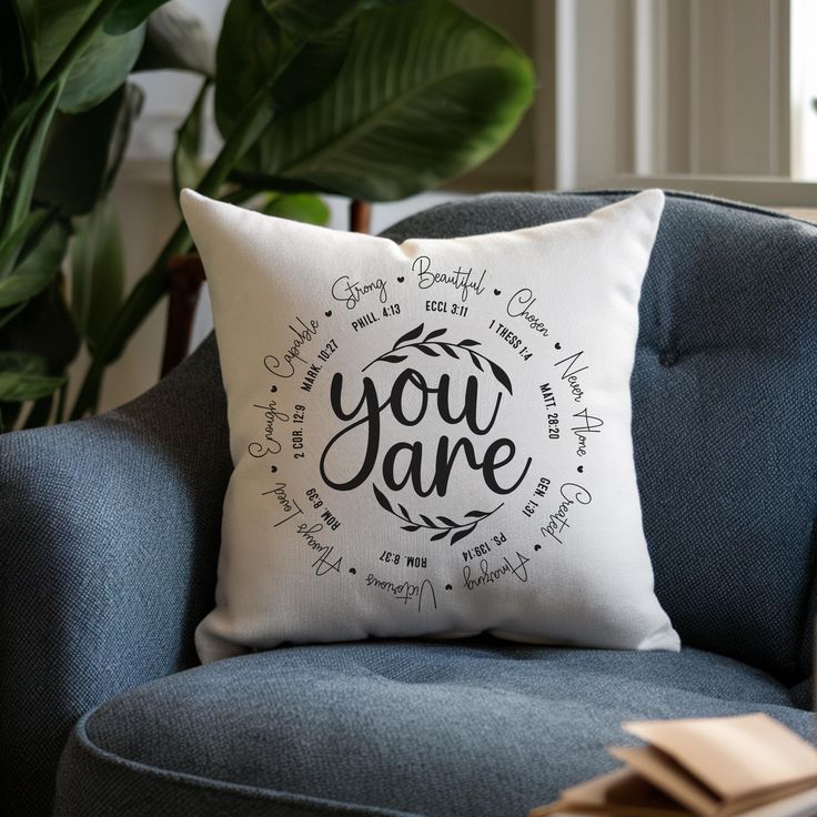 a blue chair with a white pillow that says you are surrounded by handwritten words