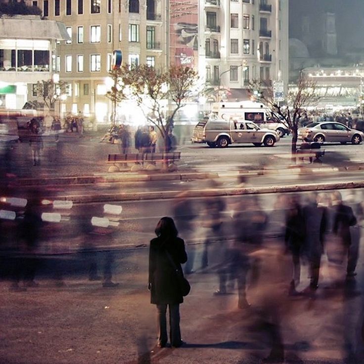 a blurry photo of people walking down the street in front of some tall buildings