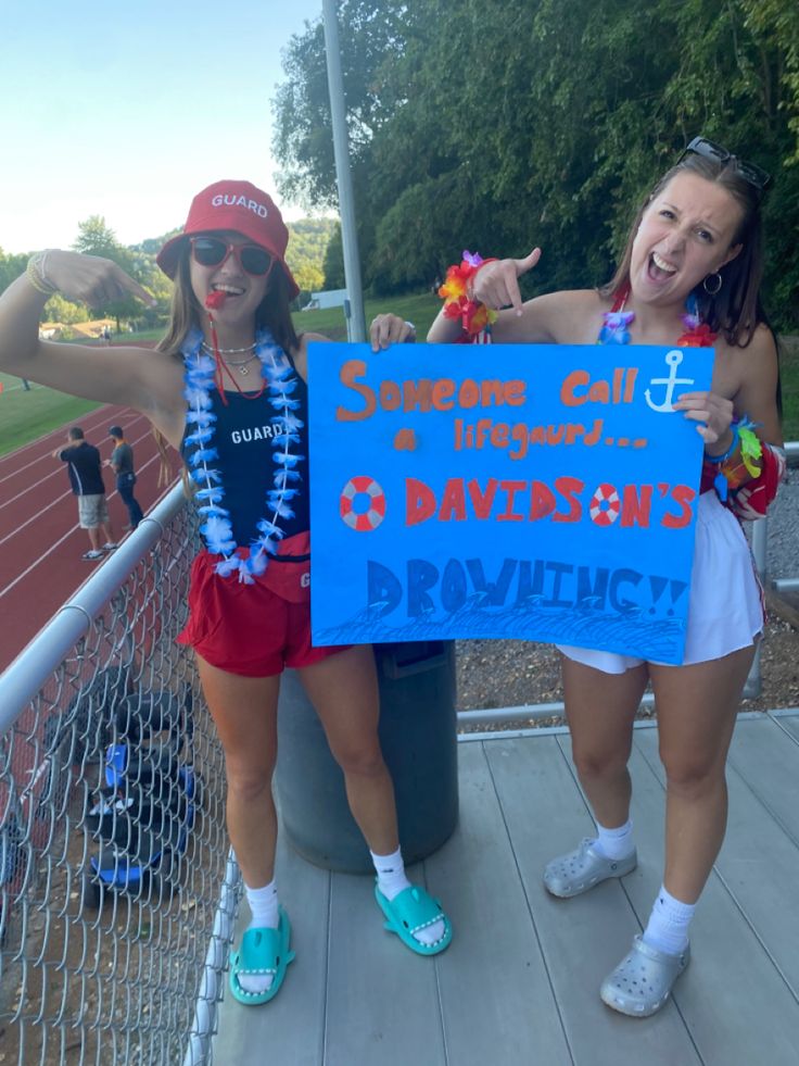 two girls holding up a sign at a baseball game