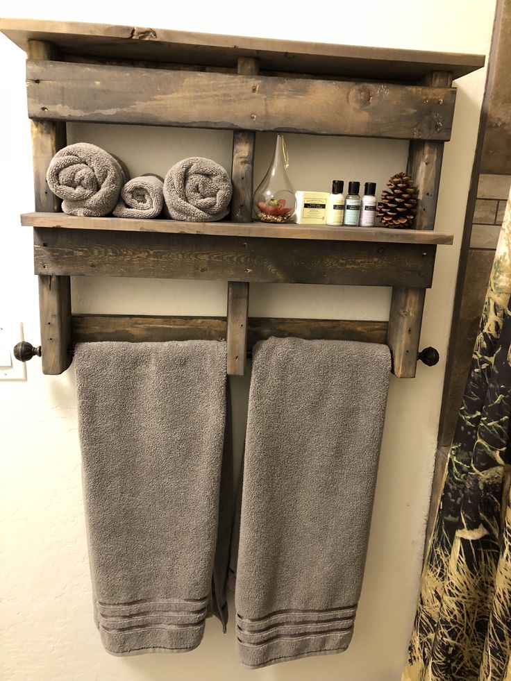 two towels are hanging on a wooden shelf