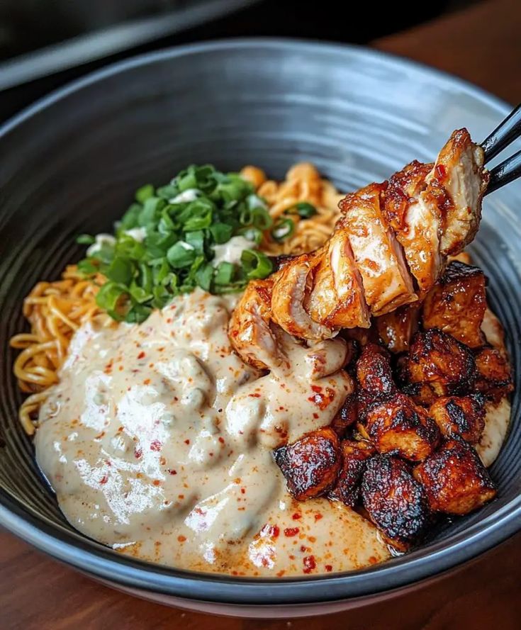 a bowl filled with meat, noodles and sauce