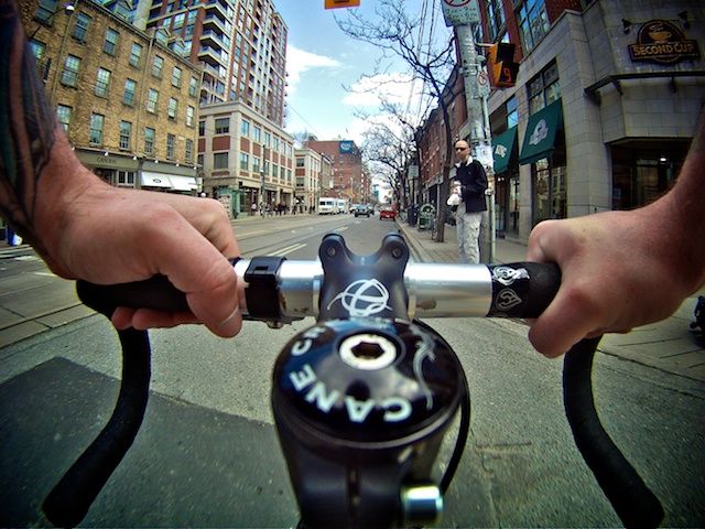 a man riding a bike down a street next to tall buildings