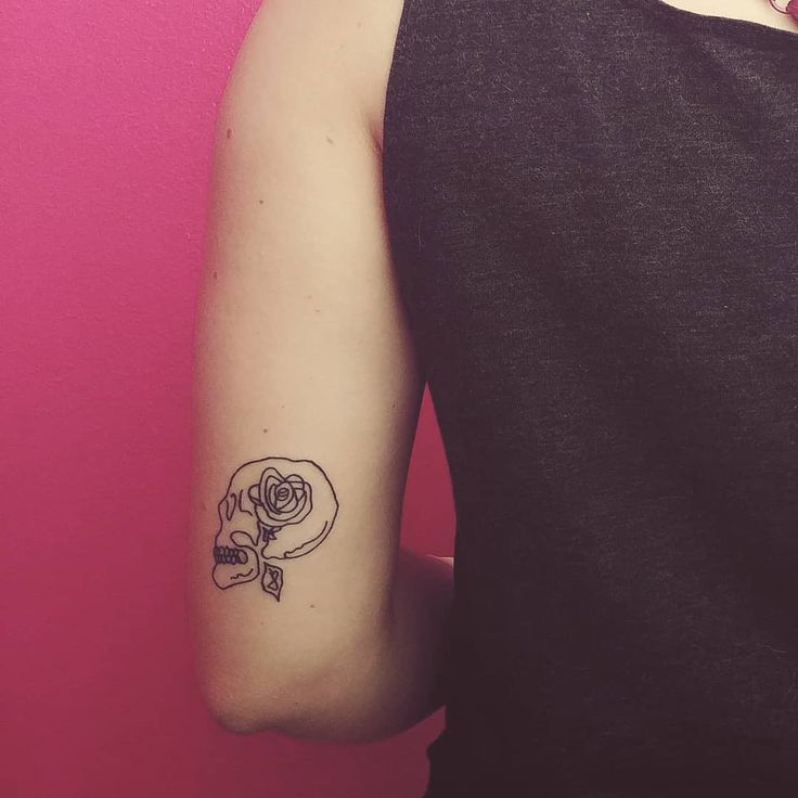 a woman's arm with a rose tattoo on the left side of her arm