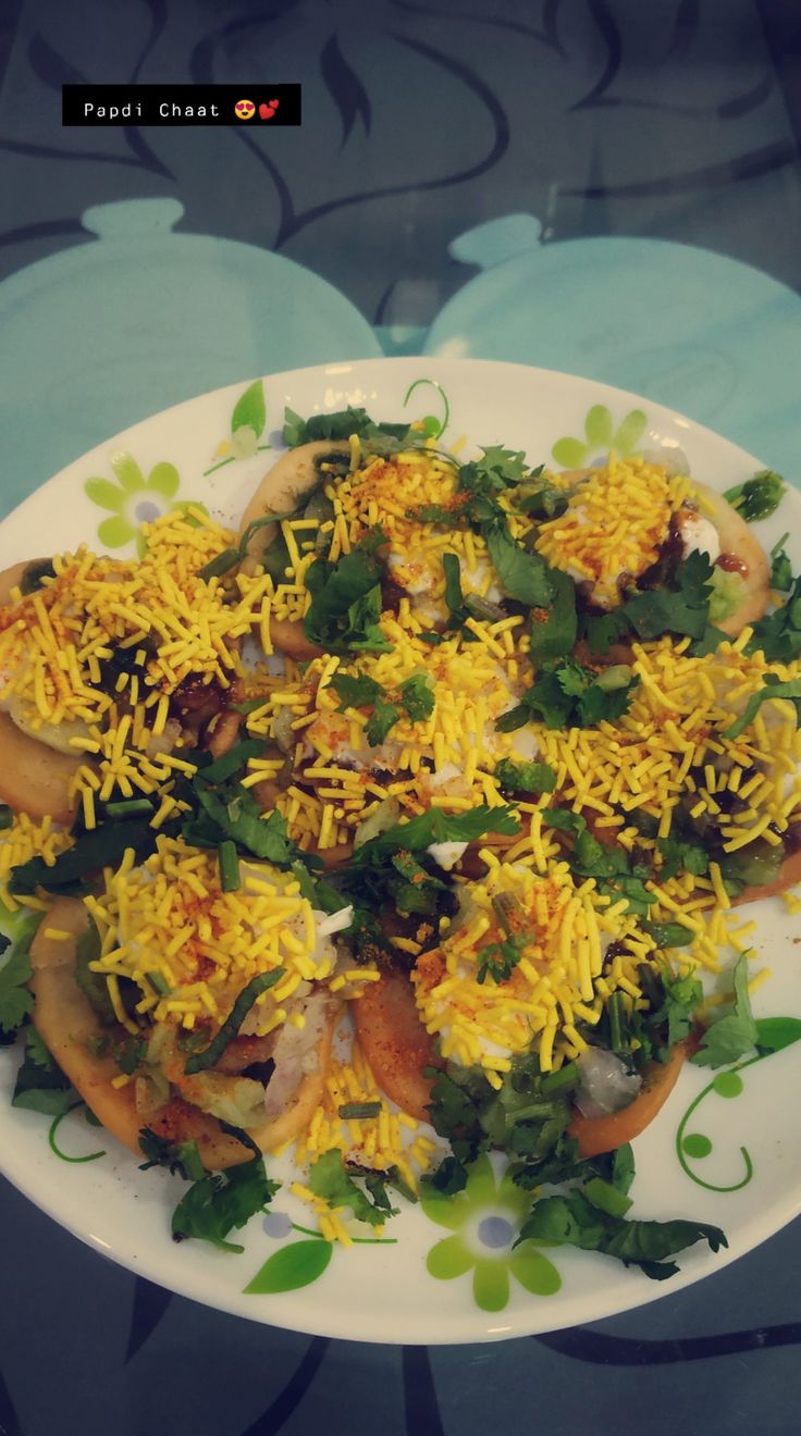 a white plate topped with lots of food on top of a blue and green table